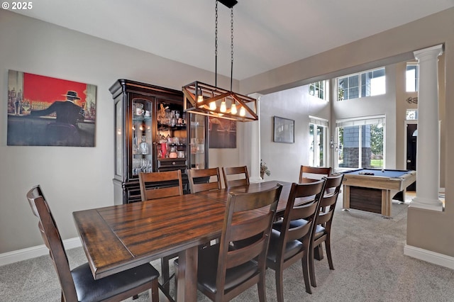 carpeted dining room with decorative columns