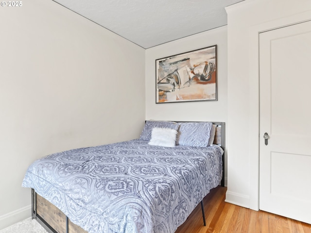 bedroom featuring wood finished floors and baseboards