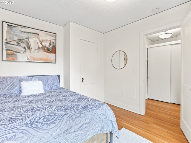 bedroom featuring light wood-type flooring and a textured ceiling