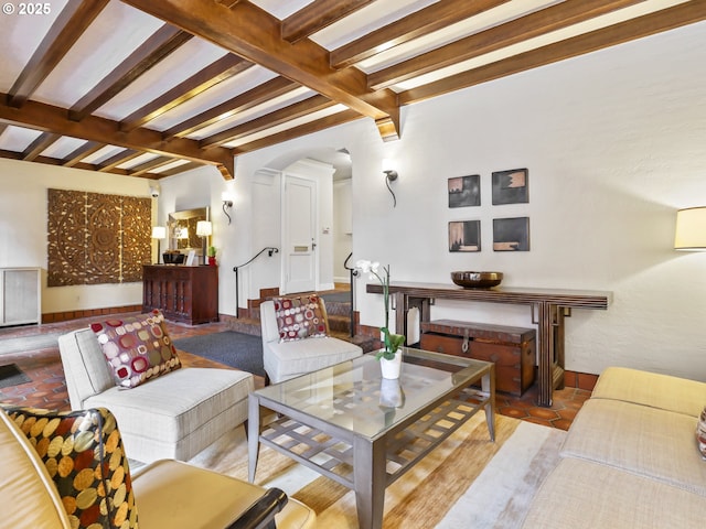 living area with arched walkways and vaulted ceiling with beams