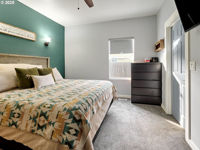 bedroom featuring ceiling fan, carpet flooring, and a textured ceiling