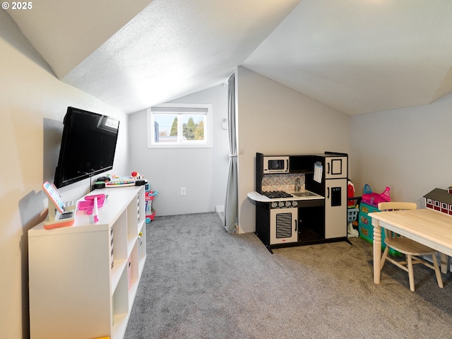 rec room featuring lofted ceiling, light colored carpet, and a textured ceiling