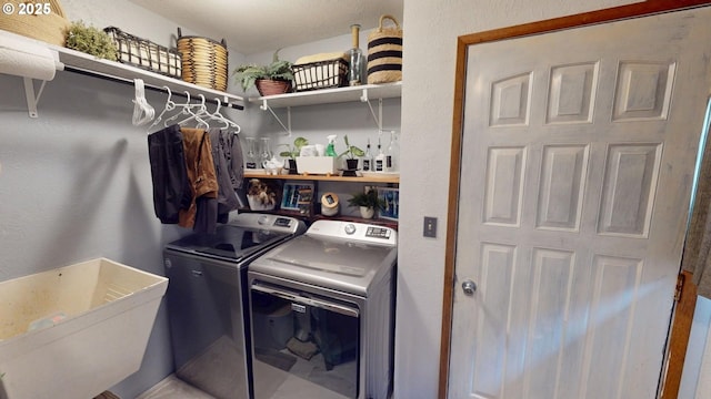 clothes washing area with sink and independent washer and dryer