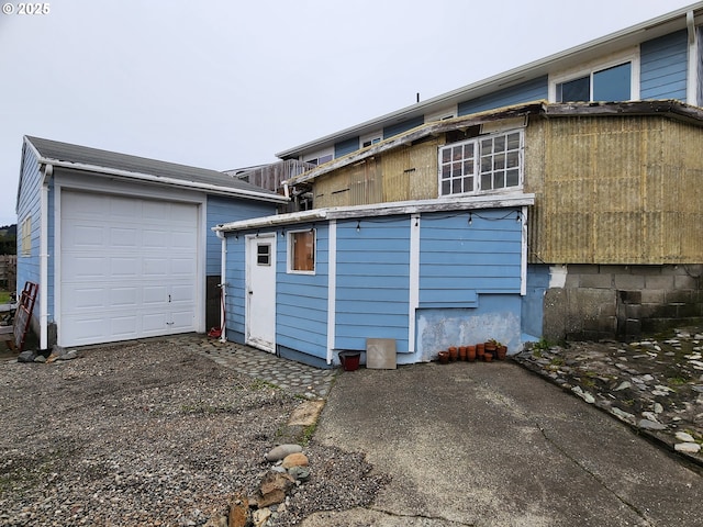 rear view of house featuring an outbuilding and a garage