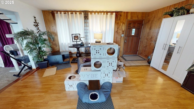 recreation room with wooden walls and light hardwood / wood-style flooring