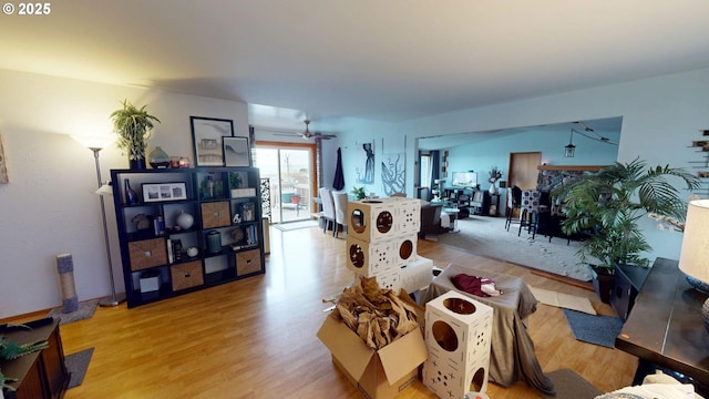 living room featuring light hardwood / wood-style flooring and ceiling fan