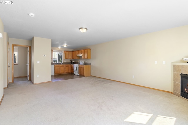unfurnished living room featuring baseboards, light colored carpet, and a fireplace