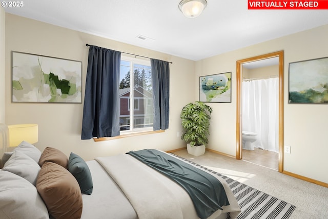 bedroom featuring visible vents, carpet flooring, baseboards, and ensuite bath