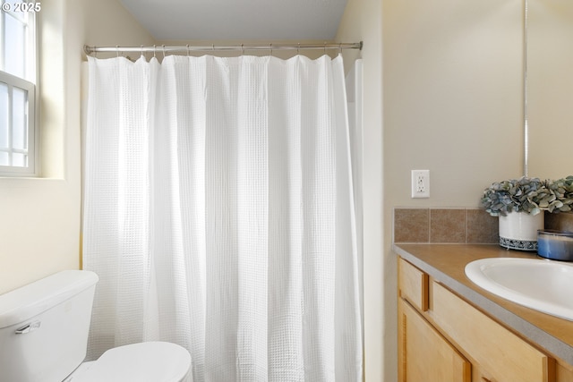 bathroom featuring toilet, curtained shower, and vanity