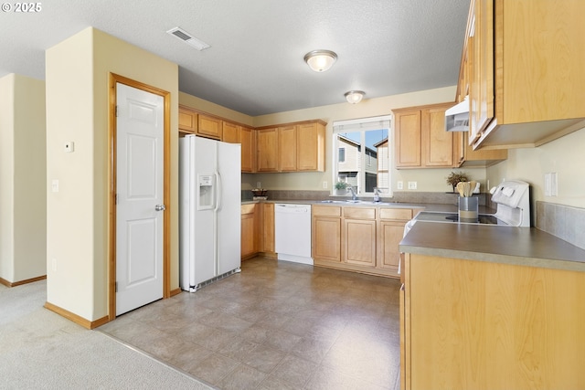 kitchen featuring light brown cabinets, white appliances, baseboards, range hood, and visible vents