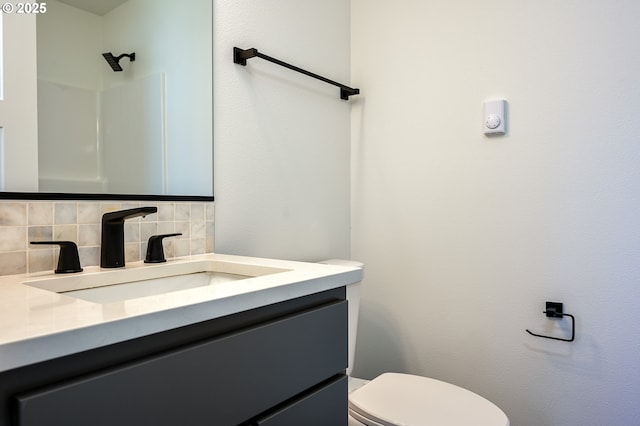 bathroom featuring decorative backsplash, toilet, and vanity