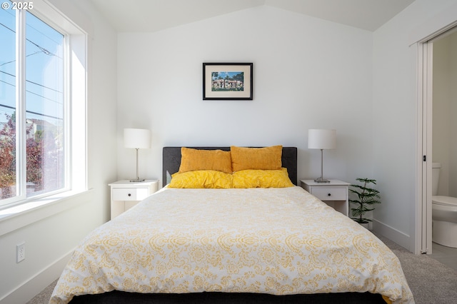 carpeted bedroom featuring vaulted ceiling and baseboards