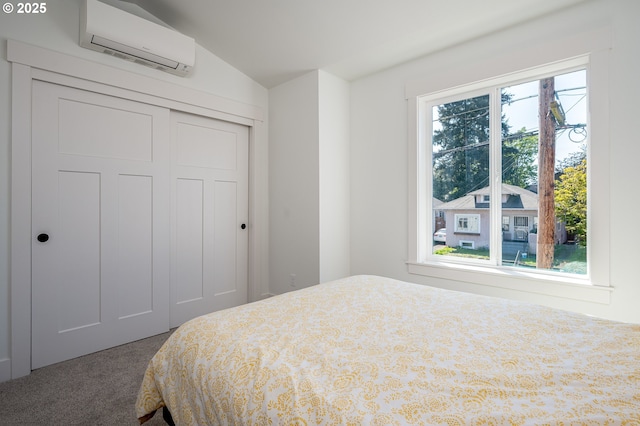 bedroom with lofted ceiling, a closet, carpet flooring, and a wall unit AC