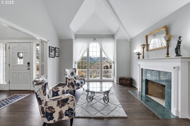 living area featuring wood finished floors, a fireplace, and vaulted ceiling