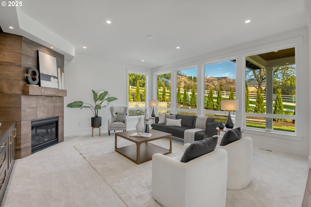 living area featuring healthy amount of natural light, recessed lighting, a fireplace, and light carpet