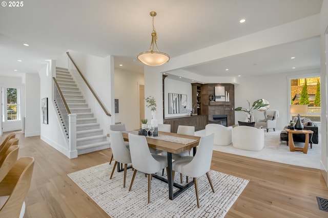 2258 Satter St, West Linn, OR 97068 - dining room featuring plenty of natural light, light wood finished floors, stairway, recessed lighting, and a tile fireplace