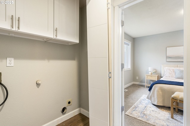 laundry room featuring electric dryer hookup, baseboards, and cabinet space