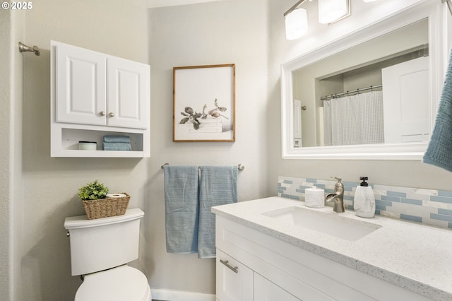 full bathroom with decorative backsplash, toilet, and vanity