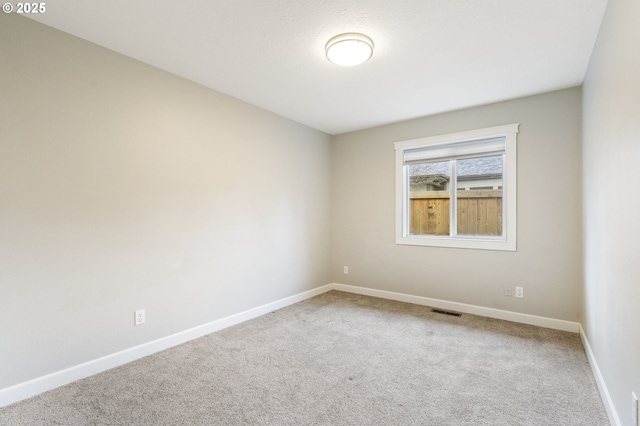 empty room featuring baseboards, visible vents, and carpet floors