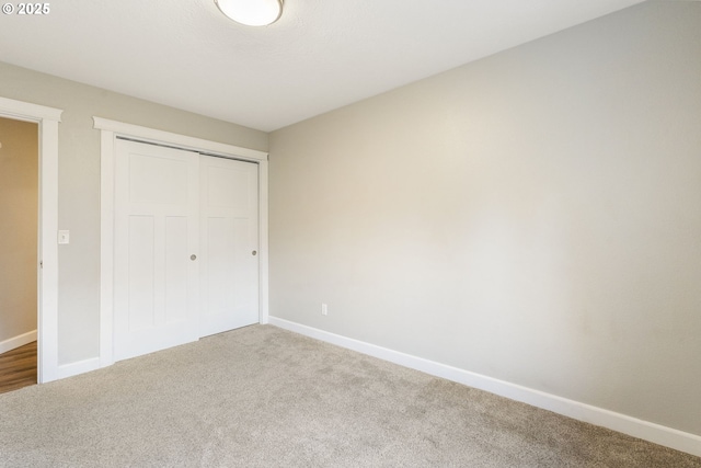 unfurnished bedroom featuring a closet, carpet flooring, and baseboards