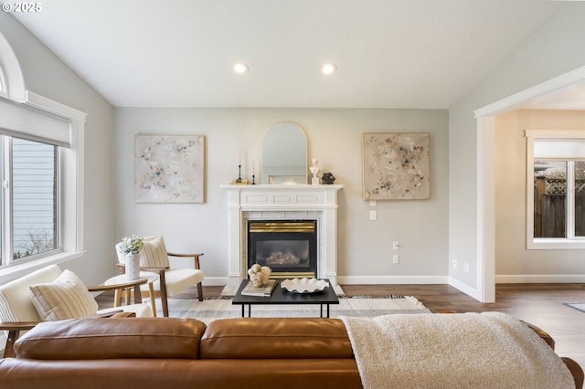 living area featuring recessed lighting, a fireplace, baseboards, and wood finished floors