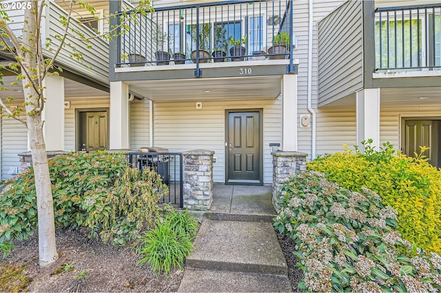 entrance to property featuring a balcony and a porch