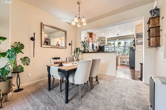 carpeted dining room with baseboards and an inviting chandelier