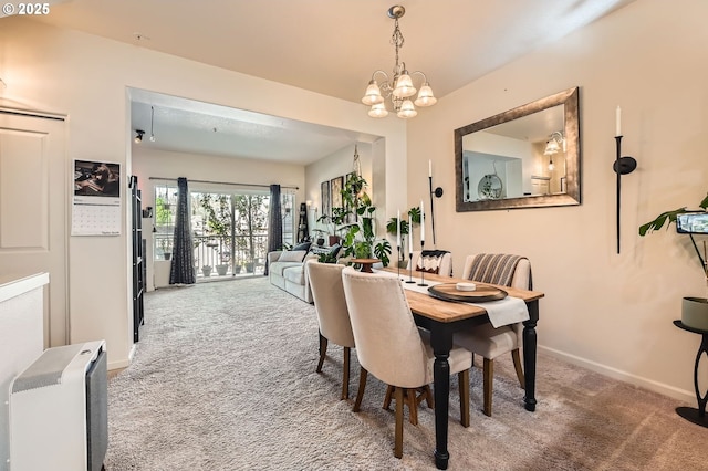 carpeted dining room with an inviting chandelier and baseboards