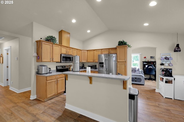 25246 Corky Ln, Veneta, OR 97487 - kitchen featuring appliances with stainless steel finishes, vaulted ceiling, light wood finished floors, a center island, and a breakfast bar