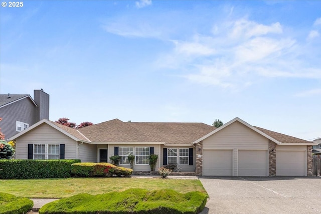 ranch-style home featuring an attached garage, a front lawn, brick siding, and asphalt driveway