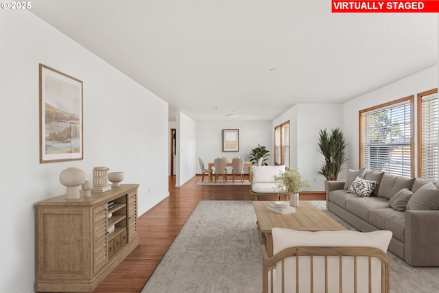 living area with light wood-style flooring and baseboards