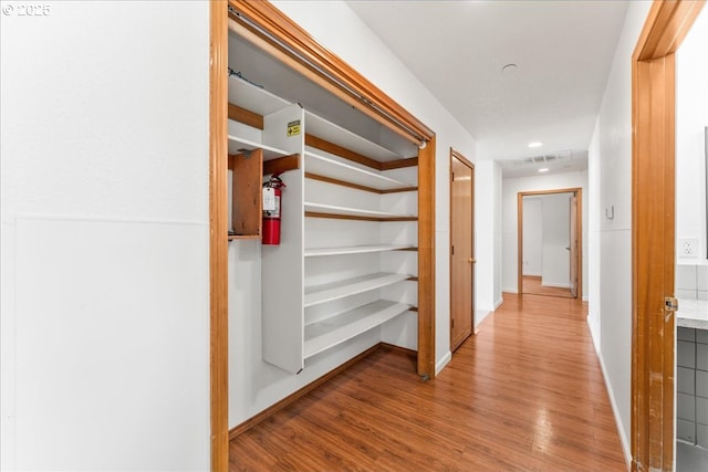 corridor featuring wood finished floors and baseboards