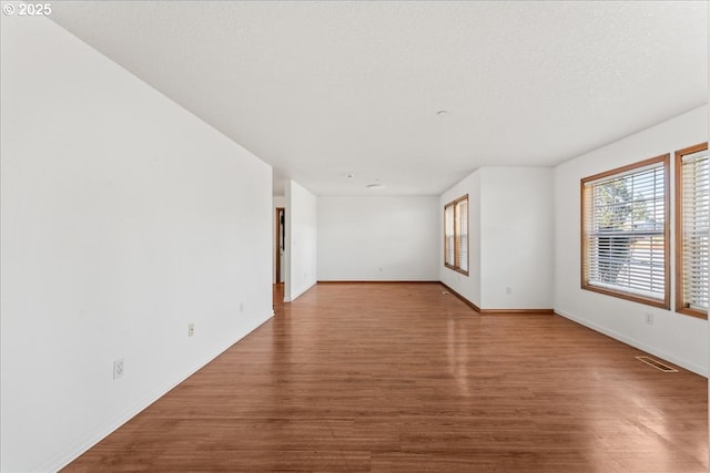 unfurnished room with wood finished floors and baseboards