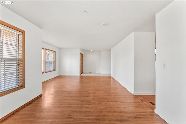 spare room with light wood-style flooring and baseboards