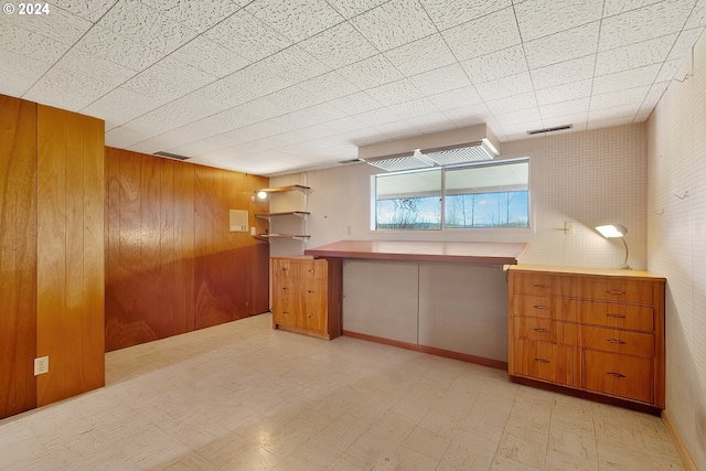 1520 Main St, Forest Grove, OR 97116 - kitchen featuring light floors, wooden walls, and brown cabinetry