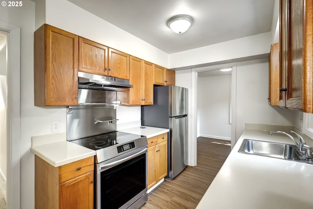 11355 SW 97th Ct, Portland, OR 97223 - kitchen with under cabinet range hood, appliances with stainless steel finishes, light wood finished floors, and light countertops
