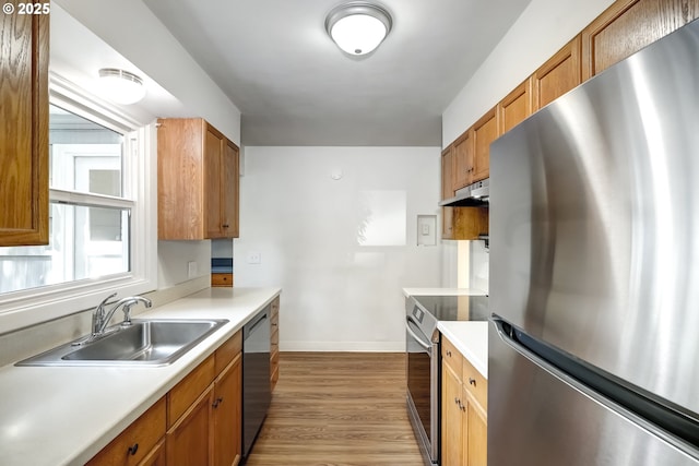 11355 SW 97th Ct, Portland, OR 97223 - kitchen with appliances with stainless steel finishes, under cabinet range hood, light wood finished floors, light countertops, and brown cabinets