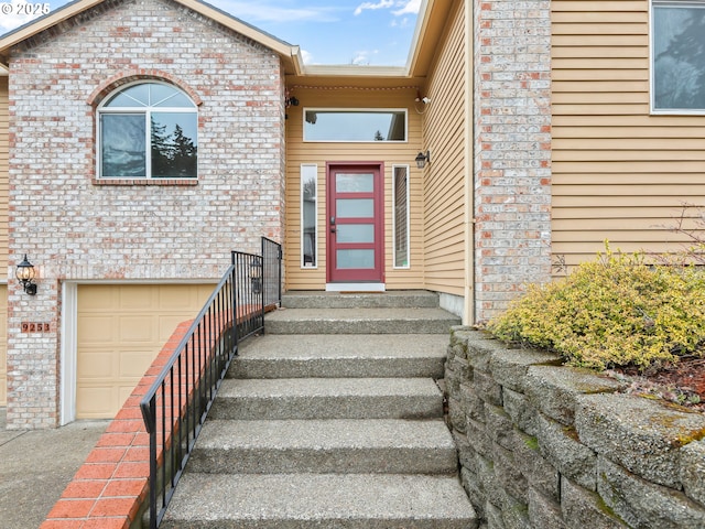 property entrance featuring a garage and brick siding