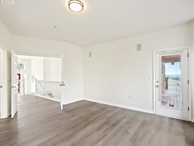 empty room featuring visible vents, baseboards, and wood finished floors