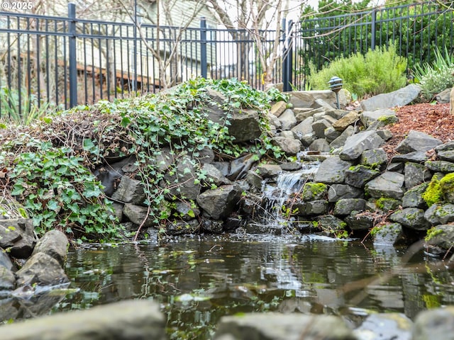 exterior details with fence and a garden pond