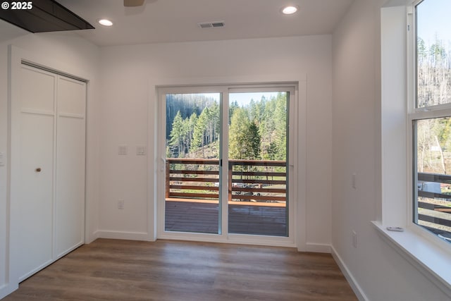 doorway featuring a healthy amount of sunlight, visible vents, wood finished floors, and recessed lighting