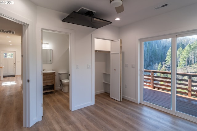 bedroom with baseboards, wood finished floors, visible vents, and recessed lighting