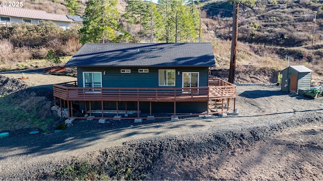 view of front facade featuring a deck and a storage shed