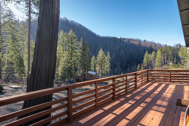 wooden terrace with a wooded view