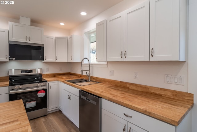 kitchen featuring recessed lighting, a sink, white cabinetry, wooden counters, and appliances with stainless steel finishes