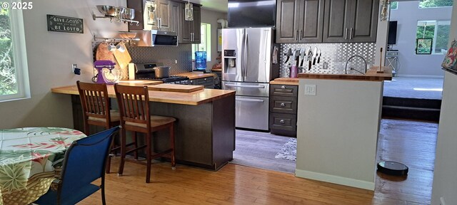 62760 Koski Rd, Coos Bay, OR 97420 - kitchen with appliances with stainless steel finishes, wood counters, tasteful backsplash, and a kitchen bar