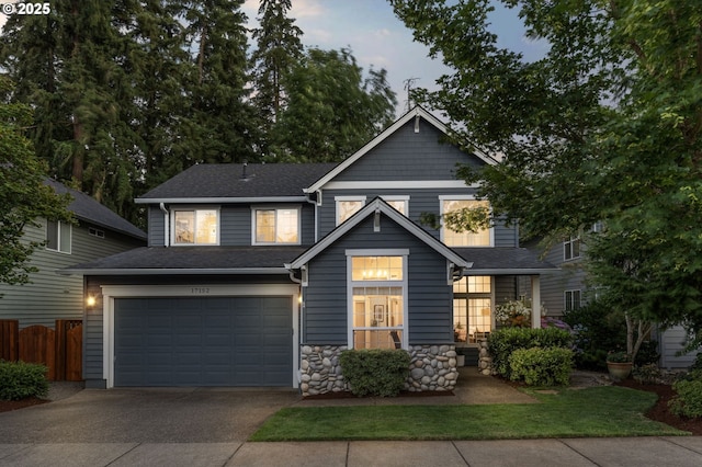 view of front of property with an attached garage, a shingled roof, driveway, and fence