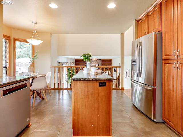 kitchen with appliances with stainless steel finishes, a kitchen island, dark stone countertops, recessed lighting, and light tile patterned flooring