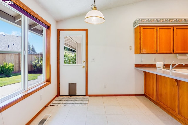 7236 Woodcrest Ct, Keizer, OR 97303 - kitchen with a sink, plenty of natural light, lofted ceiling, brown cabinets, and decorative light fixtures