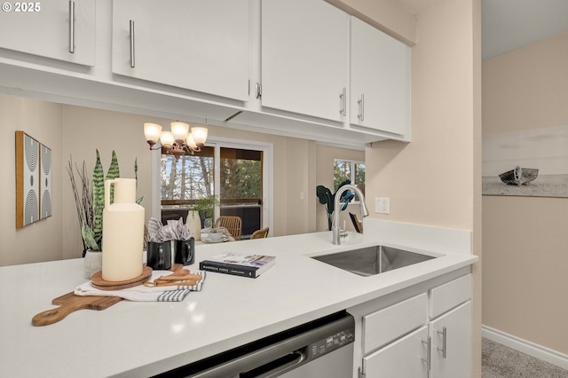 kitchen with white cabinetry, sink, and a chandelier